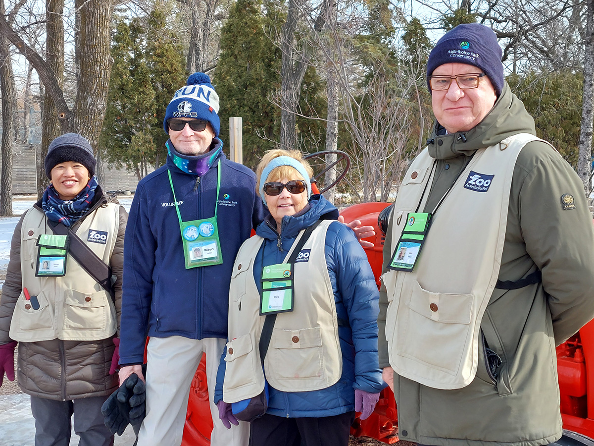 four volunteers smile to the camera wearing winter clothing